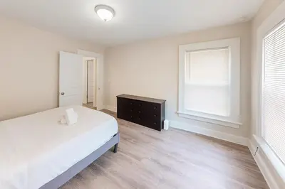 a bedroom with a bed and a dresser and a window at Downtown Haven Walk to Yale Renovated Parking in New Haven