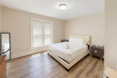 a bedroom with a white bed and a wooden floor at Downtown Haven Walk to Yale Renovated Parking in New Haven