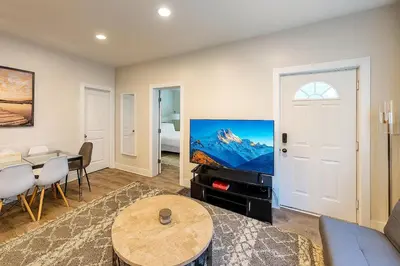 a living room with a couch and a tv and a table at Downtown Haven Walk to Yale Renovated Parking in New Haven