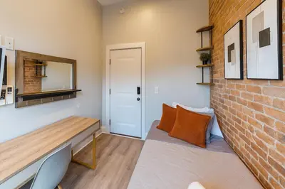 a room with a bench and a brick wall at Bright Downtown Room near Yale & East Rock! in New Haven