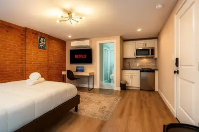 a bedroom with a bed and a desk and a kitchen at Perfect Downtown Stay Yale Walk Sallys Apizza in New Haven