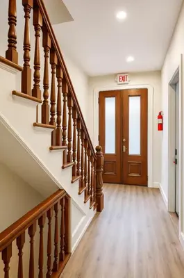 a hallway with stairs with a exit sign on the door at Perfect Downtown Stay Yale Walk Sallys Apizza in New Haven