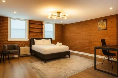 a bedroom with a bed and a brick wall at Perfect Downtown Stay Yale Walk Sallys Apizza in New Haven