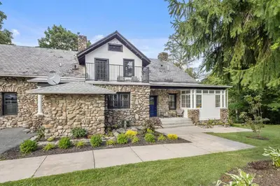 a stone house with a balcony and a driveway at Lakeview-Sleeps 12-King Suites-7BR - Firepit in Monroe