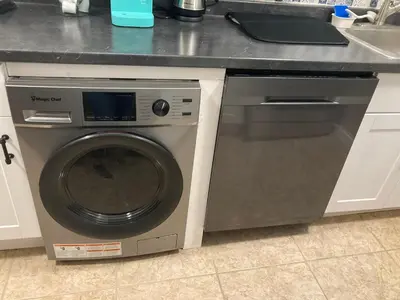a washing machine in a kitchen next to a sink at Cozy Condo Jersey City in Jersey City