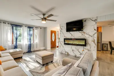 a living room with a couch and a fireplace at 2 Mi to Town Home with Patio and Yard in Waterbury! in Waterbury