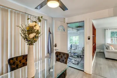 a living room with a vase with flowers in it at 2 Mi to Town Home with Patio and Yard in Waterbury! in Waterbury