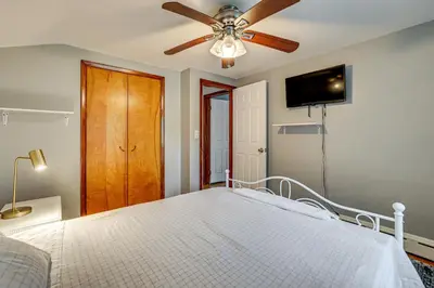 a bedroom with a bed with a ceiling fan at 2 Mi to Town Home with Patio and Yard in Waterbury! in Waterbury