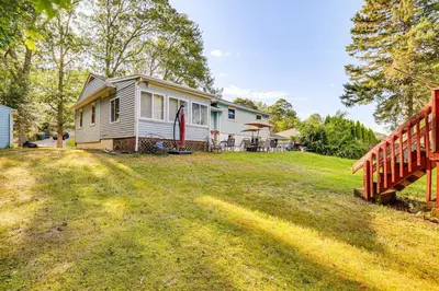 a house with a wooden fence in a yard at 2 Mi to Town Home with Patio and Yard in Waterbury! in Waterbury