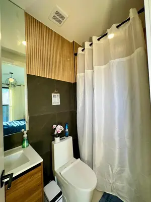 a bathroom with a toilet and a white shower curtain at BP STAYS - Hotel-Style, No Host, Professionally Managed ID286 in Jersey City