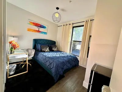 a bedroom with a bed and a desk and a window at BP STAYS - Hotel-Style, No Host, Professionally Managed ID286 in Jersey City