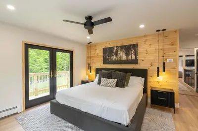 a bedroom with a bed and a ceiling fan at Modern Catskills Retreat with Creek & Fire Pit in Cairo
