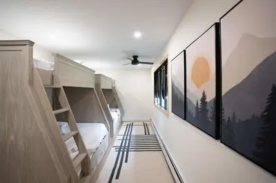 a room with bunk beds and paintings on the walls at Modern Catskills Retreat with Creek & Fire Pit in Cairo