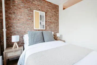 a bedroom with a brick wall and a bed at Spacious 3BR Upper West Side Apt - Steps from Central Park in New York