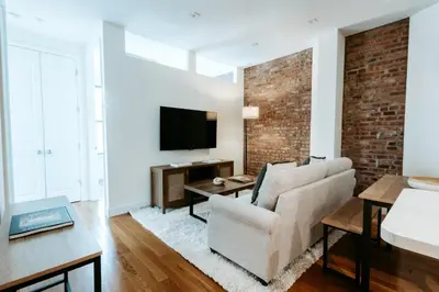 a living room with a couch and a tv at Spacious 3BR Upper West Side Apt - Steps from Central Park in New York