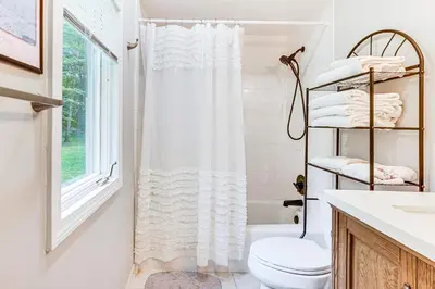a bathroom with a white shower curtain and a toilet at Pet-Friendly Cottage, 2 Mi to Saugatuck Falls in Redding