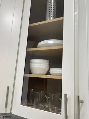 a kitchen cabinet with plates and dishes in it at Modern 2BR and Office Near NYC With Parking - Sleeps 6 in Jersey City