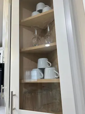 a cabinet filled with cups and saucers at Modern 2BR and Office Near NYC With Parking - Sleeps 6 in Jersey City