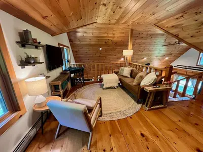 a living room with a couch and a tv at Perfect Vermont Battenkill Log Cabin in Arlington