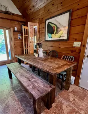 a dining room with a wooden table and benches at Perfect Vermont Battenkill Log Cabin in Arlington