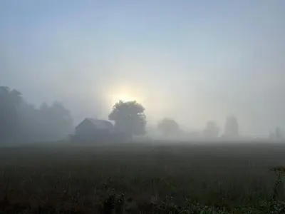 a foggy field with a house in the middle at Perfect Vermont Battenkill Log Cabin in Arlington