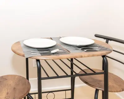 a table with two white plates on top of it at Albany Studio with Kitchen, WiFi, Gym and Game Room Near Capitol in Albany