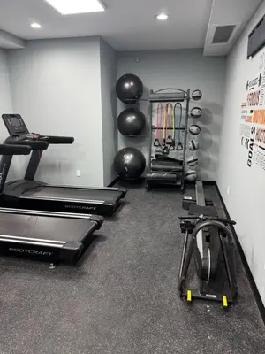 a gym with several treadmills and exercise bikes at Albany Studio with Kitchen, WiFi, Gym and Game Room Near Capitol in Albany
