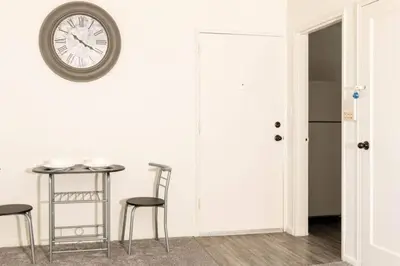 a room with a table and chairs and a clock on the wall at Spacious 1-Bedroom Condo with Kitchen, Free Parking and Fitness Center in Albany