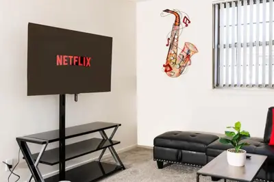 a living room with a black couch and a television at Spacious 1-Bedroom Condo with Kitchen, Free Parking and Fitness Center in Albany