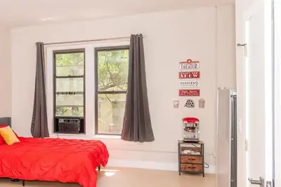 a bedroom with a red bed and a window at Central Albany Apartment with WiFi Walk to Capitol and Empire Plaza in Albany