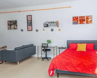 a bedroom with a red bed and a couch at Central Albany Apartment with WiFi Walk to Capitol and Empire Plaza in Albany