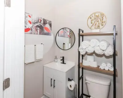 a bathroom with a toilet and a shelf with towels at Central Albany Apartment with WiFi Walk to Capitol and Empire Plaza in Albany