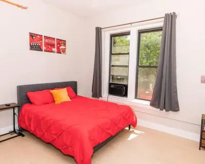 a bedroom with a red bed and a window at Central Albany Apartment with WiFi Walk to Capitol and Empire Plaza in Albany