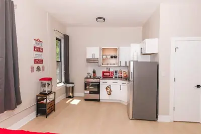 a kitchen with white cabinets and a refrigerator at Central Albany Apartment with WiFi Walk to Capitol and Empire Plaza in Albany