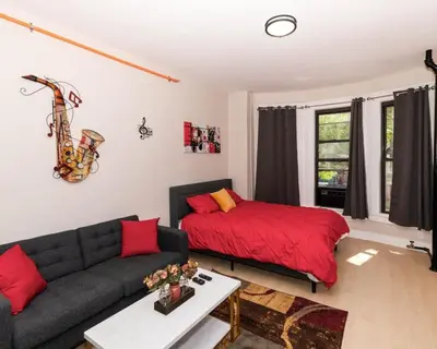 a living room with a couch and a bed at Central Albany Apartment Private Unit Near Capitol and Empire Plaza in Albany