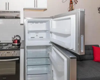 an empty refrigerator with its door open in a kitchen at Central Albany Apartment Private Unit Near Capitol and Empire Plaza in Albany