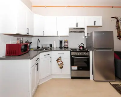 a kitchen with white cabinets and a stainless steel refrigerator at Central Albany Apartment Private Unit Near Capitol and Empire Plaza in Albany