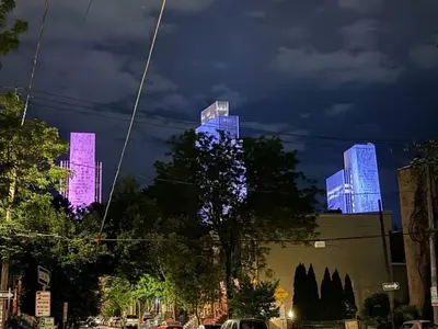 a group of tall buildings lit up at night at Central Albany Apartment Private Unit Near Capitol and Empire Plaza in Albany