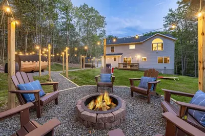 a backyard with a fire pit and chairs and a house at Best Deal in the Poconos! in Tobyhanna