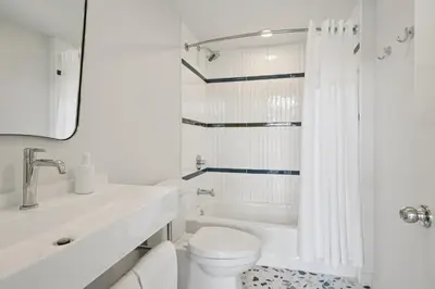 a white bathroom with a toilet and a bath tub at Lakelyn Lodge in Lakeville