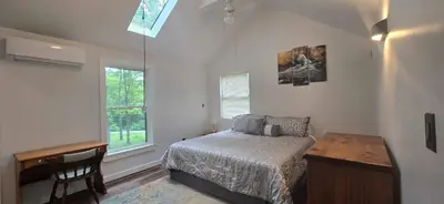 a bedroom with a bed and a desk and a window at Views, Pines & Perfect Vibes in Middleburgh
