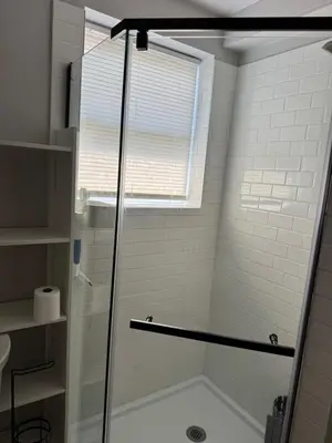 a shower with a glass door in a bathroom at Calm Retreat in Plainview