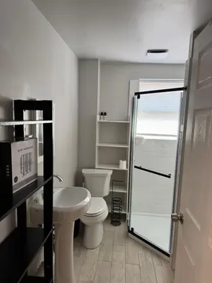 a bathroom with a toilet and a sink and a shower at Calm Retreat in Plainview