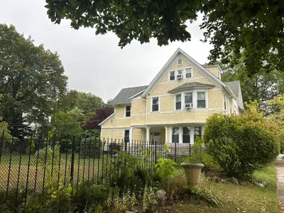 a yellow house with a fence in front of it at Historic Springfield Home in Springfield