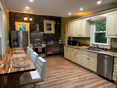 a kitchen with white cabinets and a wooden table at Historic Springfield Home in Springfield