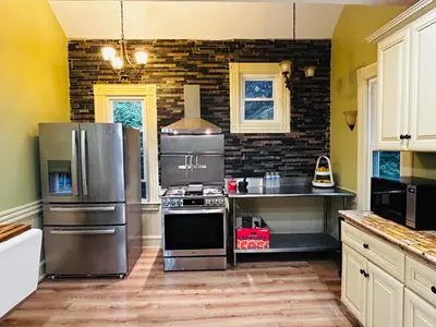 a kitchen with stainless steel appliances and a brick wall at Historic Springfield Home in Springfield