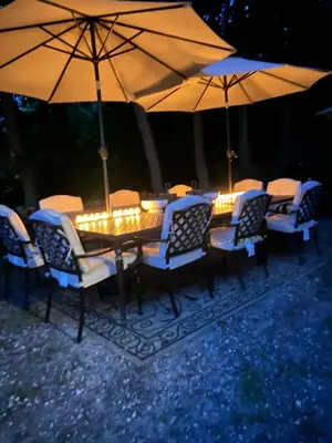 a wooden table with chairs and umbrellas at night at The Allen House in North Adams
