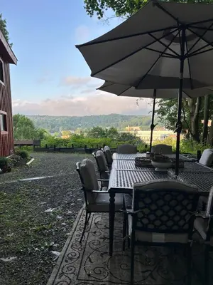 a table with chairs and an umbrella on a patio at The Allen House in North Adams