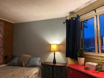 a bedroom with a bed and a table with a lamp at The Allen House in North Adams