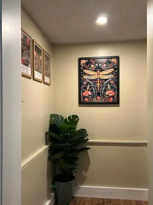 a hallway with a painting on the wall and a plant at The Allen House in North Adams